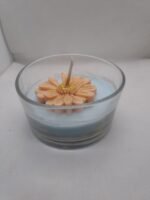 Add a touch of elegance and serenity to your home with this beautifully handcrafted floral candle. Featuring a delicate peach flower with a shimmering golden center, set on a soft sky-blue wax base inside a premium clear glass jar, this candle is perfect for creating a warm and relaxing atmosphere.